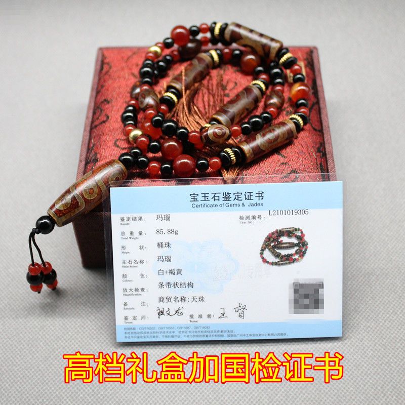 Close-up of authentic Tibetan dzi beads with intricate three-eye and nine-eye symbols, glowing with natural agate hues.
