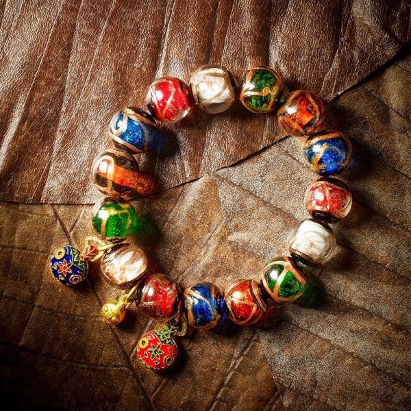 Close-up of genuine agate Three Nine-Eye Dzi beads with intricate dragon carving, radiating prosperity energy.