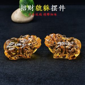 Golden Citrine Pi Yao statue glowing under light, symbolizing wealth attraction and Feng Shui prosperity.