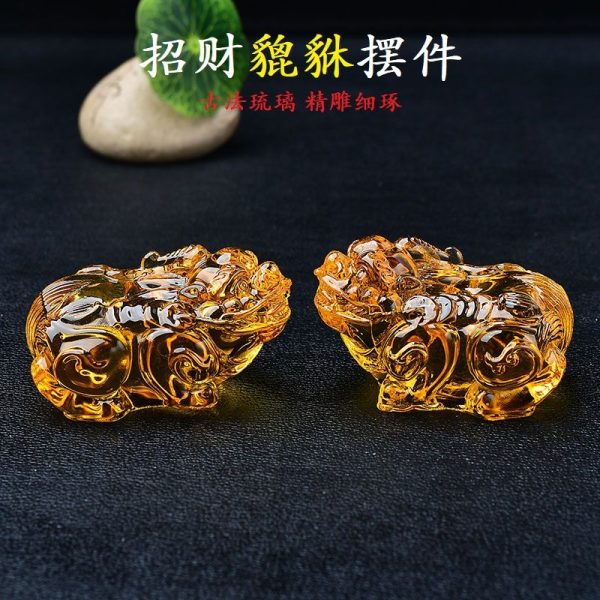 Golden Citrine Pi Yao statue glowing under light, symbolizing wealth attraction and Feng Shui prosperity.