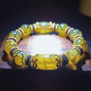 Close-up of genuine agate Three Nine-Eye Dzi beads with intricate dragon carving, radiating prosperity energy.