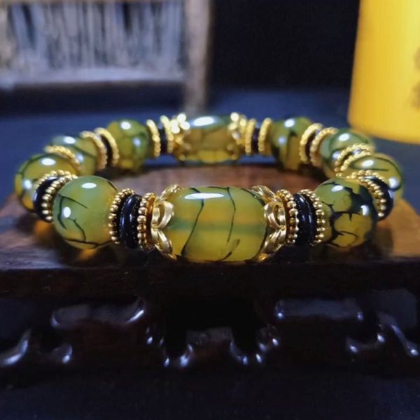 Man wearing the Dzi bead bracelet during meditation, invoking balance and cosmic blessings.